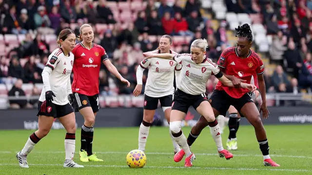 Denise O'Sullivan of Liverpool is challenged by Melvine Malard of Manchester United
