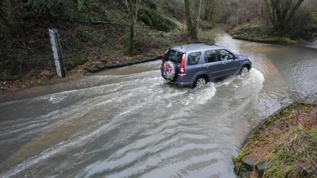 A car drives through floodwater