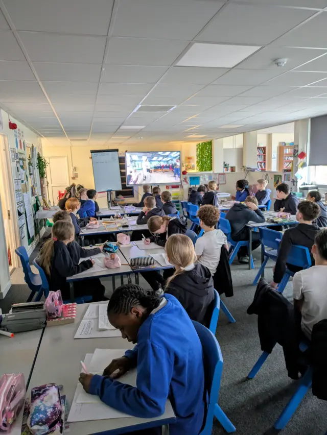 A Class creating posters while watching a Live Lesson