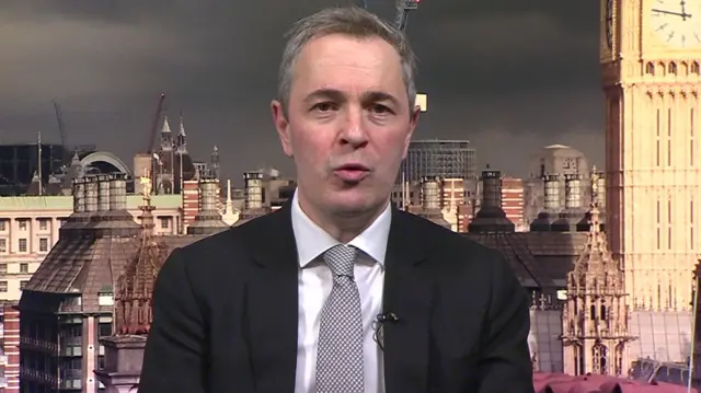 MP David Pinto-Duschinsky speaking to the BBC from their Westminster studio. He's in a black suit and white shirt with patterned black and white tie