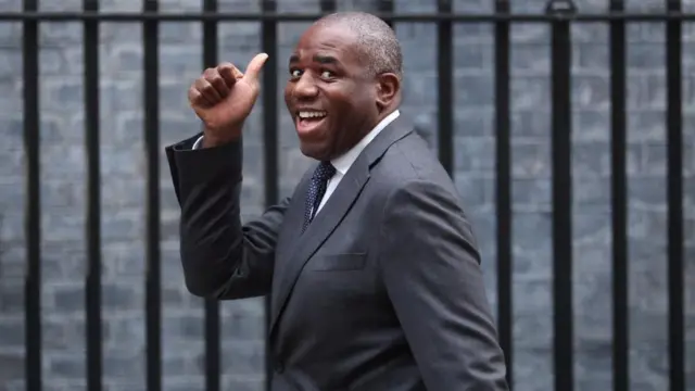 David Lammy walking up to 10 Downing Street. He's got his thumb up and is smiling at the camera