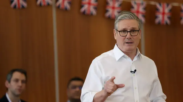 Keir Starmer speaking to a group of people sitting down around him