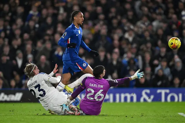 Joao Pedro of Chelsea scores his team's first goal past Karl Darlow of Leeds United, whilst under pressure from Sebastiaan Bornauw of Leeds United during the Premier League match between Chelsea and Leeds United at Stamford Bridge on February 10, 2026 in London, England.