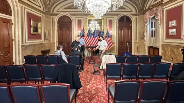 An empty room being prepared for a news conference