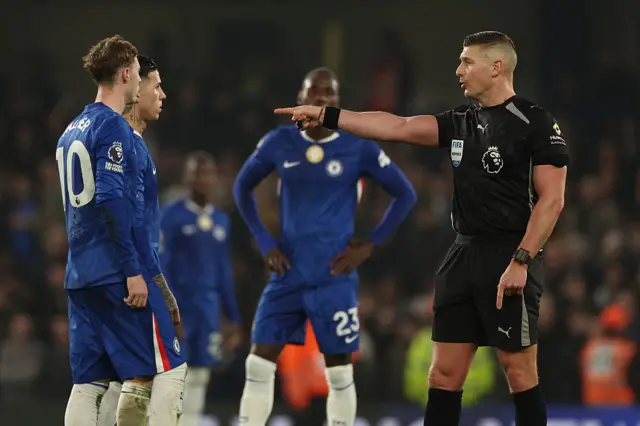 English referee Rob Jones gestures as a VAR (Video Assistant Referee) review studies the second Leeds goal during the English Premier League football match between Chelsea and Leeds United at Stamford Bridge in London on February 10, 2026.