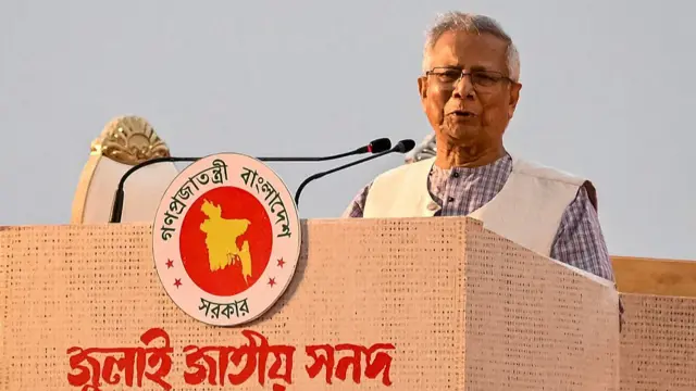 Muhammad Yunus speaking at a podium