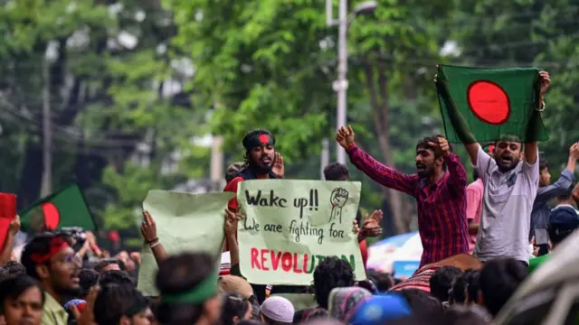 People holding up the Bangladesh flag and protest banners
