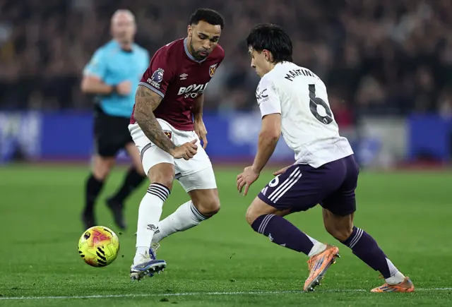 Callum Wilson of West Ham United passes the ball whilst under pressure from Lisandro Martinez of Manchester United during the Premier League match between West Ham United and Manchester United at London Stadium on February 10, 2026 in London, England.