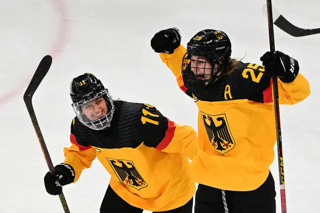 Germany's #25 Laura Kluge (R) celebrates scoring the 2-1 goal with team mate Germany's #11 Nicola Hadraschek during the women's preliminary round Group B Ice Hockey match between Italy and Germany at the Milano Rho Ice Hockey Arena at the Milano Cortina 2026 Winter Olympic Games