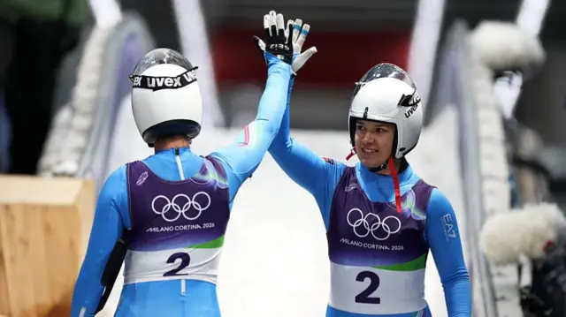 Italy's Voetter and Oberhofer hi-five after their first run