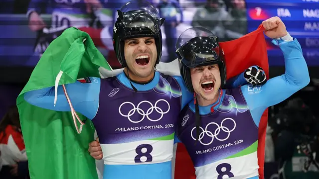 Emanuel Rieder and Simon Kainzwaldner with the Italian flag after winning the luge men's doubles
