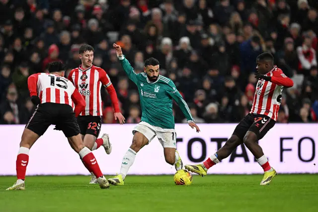 Mohamed Salah on the ball whilst under pressure from Noah Sadiki, Trai Hume and Omar Alderete