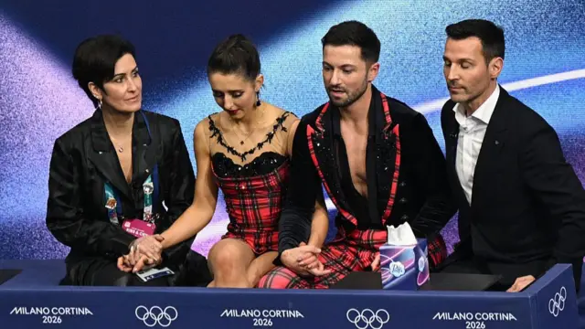Lilah Fear and Lewis Gibson sit with their team