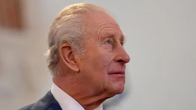 A side profile of King Charles III, who looks up