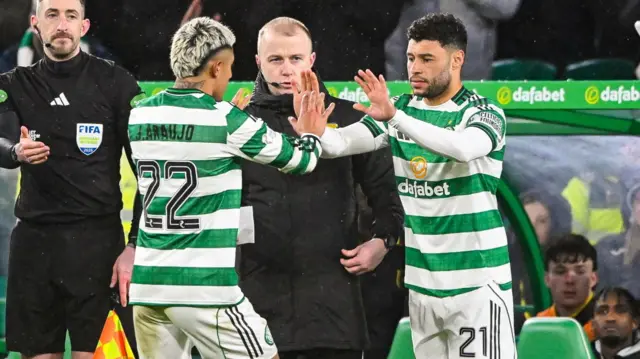 Celtic's Alex Oxlade-Chamberlain (R) and James Forrest prepare to be substituted on