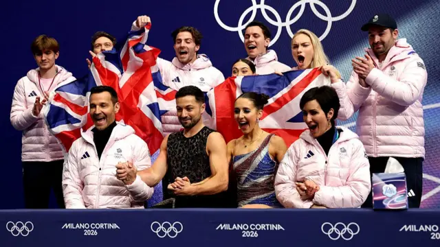 Lewis Gibson and Lilah Fear with their team receiving their score for the rhythm dance