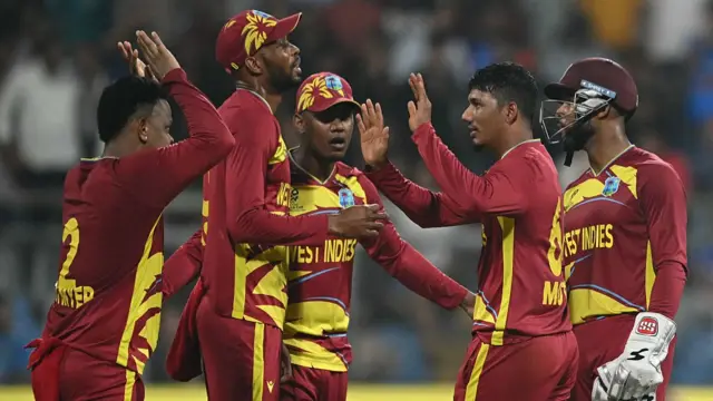 West Indies' Gudakesh Motie celebrates with teammates after taking the wicket of England's captain Harry Brook