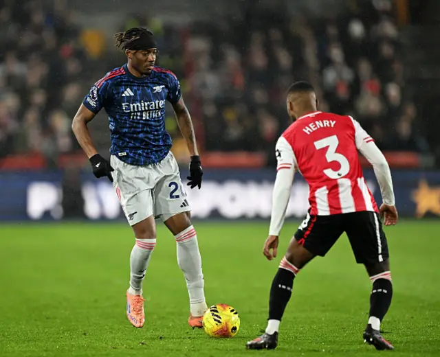 Noni Madueke of Arsenal on the ball whilst under pressure from Rico Henry