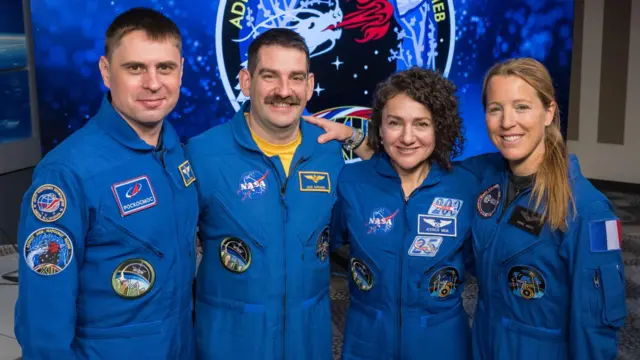 The crew members in blue jumpsuits