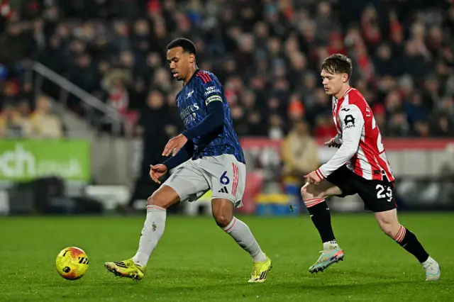 Gabriel Magalhaes passes the ball whilst under pressure from Brentford's English striker Keane Lewis-Potter
