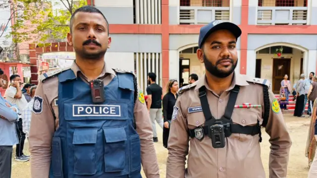Two police officers on the street look at the camera