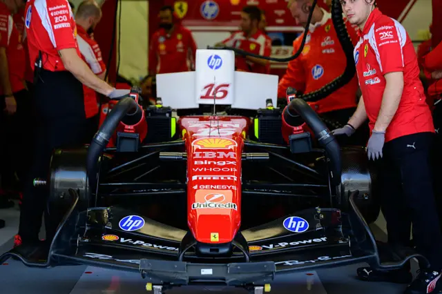Ferrari mechanics work on Charles Leclerc's car