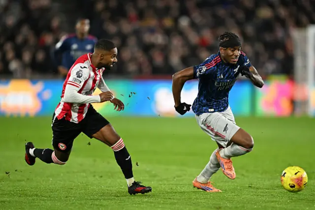 Noni Madueke of Arsenal on the ball whilst under pressure from Rico Henry