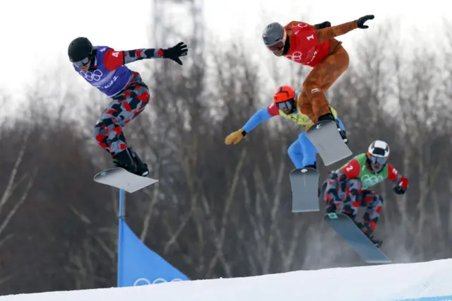 Athletes in action in the snowboard cross events at the 2022 Winter Olympics