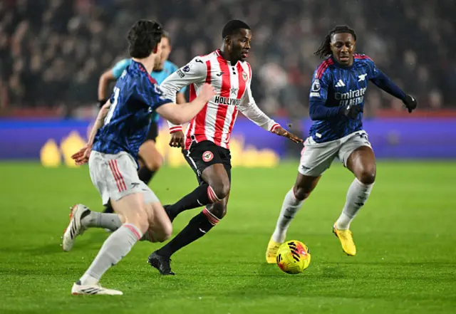 Dango Ouattara of Brentford runs with the ball whilst under pressure from Declan Rice