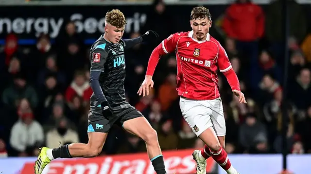 Wrexham's Callum Doyle competes with Ipswich Town's Sindre Walle Egeli during the Emirates FA Cup Fourth Round match between Wrexham and Ipswich Town