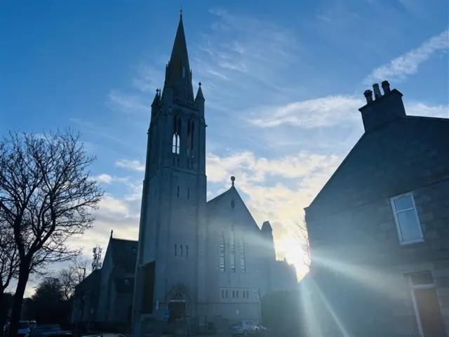 The sun shining behind a church in Aberdeen