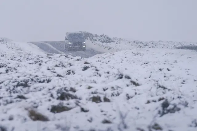 A car driving along a snowy road.