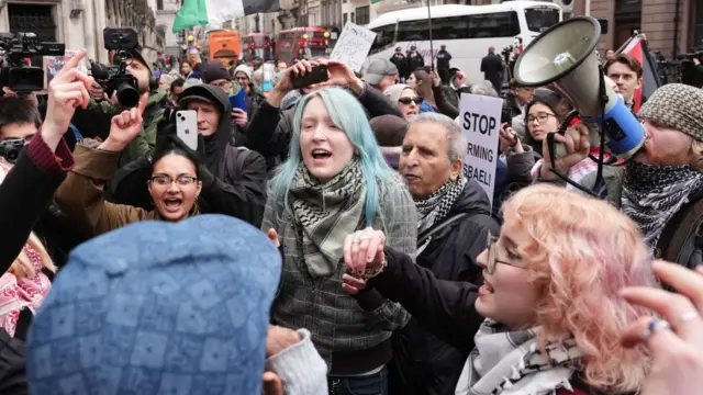 Protesters celebrate outside the High Court, central London, where Dame Victoria Sharp, Mr Justice Swift and Mrs Justice Steyn have ruled in favour of Palestine Action's co-founder Huda Ammori's challenge over the ban of the organisation as a terror group. The Government will appeal against the High Court's decision