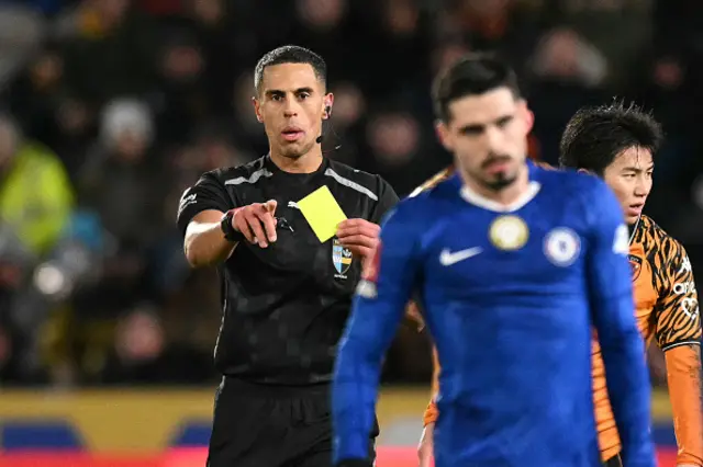 English referee Farai Hallam shows a yellow card to Chelsea's Portuguese midfielder #07 Pedro Neto