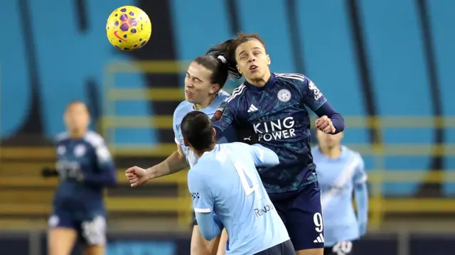 Sam Coffey challenges for a header