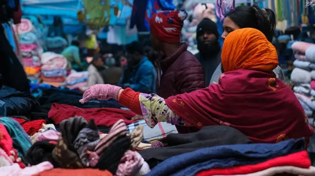 Shoppers browse through stacks of garments at a market in Bangladesh