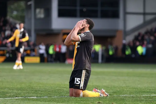 Burton player reacts to a missed chance by sinking to his knees and covering his face