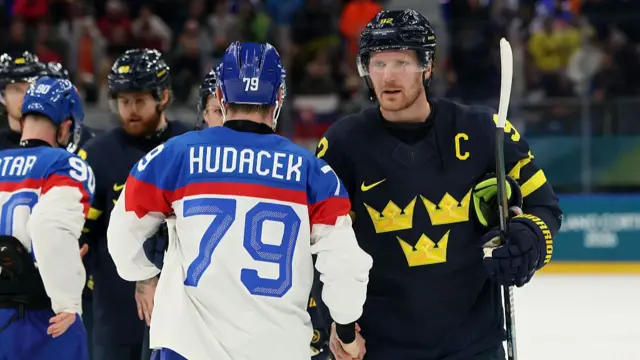 Sweden and Slovakia hockey players embrace