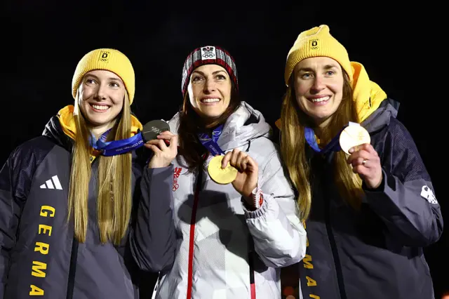 Gold medalist Janine Flock of Team Austria, Silver medalist Susanne Kreher of Team Germany, and Bronze medalist Jacqueline Pfeifer of Team Germany celebrate on the podium during the Women's Skeleton medal ceremony
