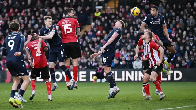 Sam Dalby (centre right) scores a header for Lincoln City