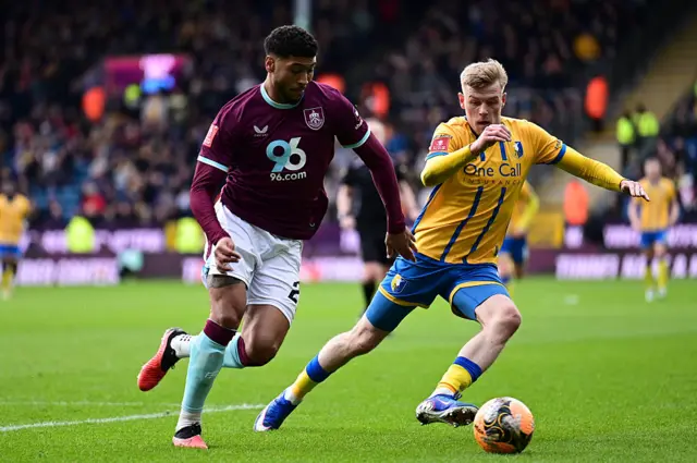 Josh Laurent competes with Mansfield Town's Will Evans