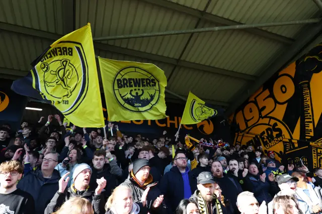 Burton supporters wave flags pree kick-off