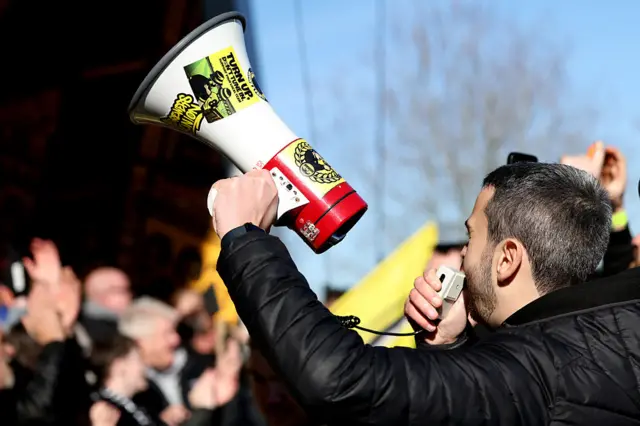 Burton fans chant with a megaphone