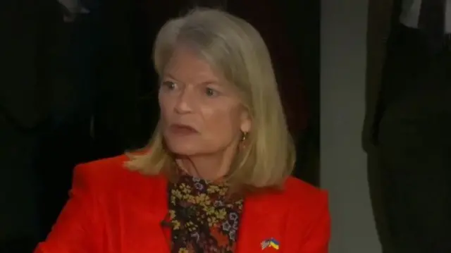 Alaska Senator Lisa Murkowski wearing a red suit jacket and floral patterned shirt