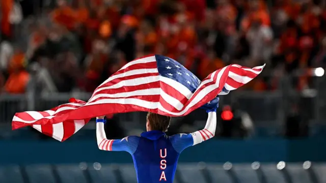 USA's Jordan Stolz waves his country's flag