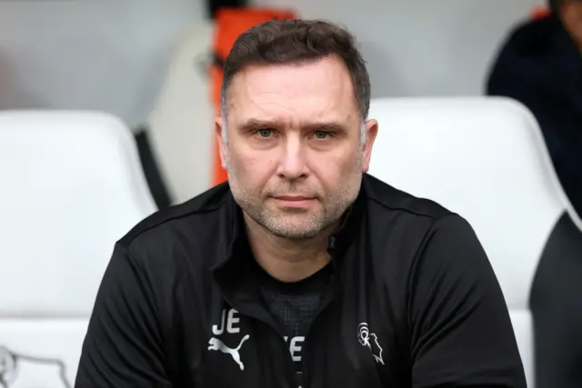 Derby boss John Eustace holds a poker-face expression while sat in the dugout