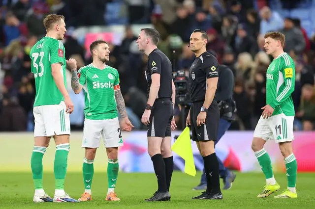 Newcastle players argue with the ref