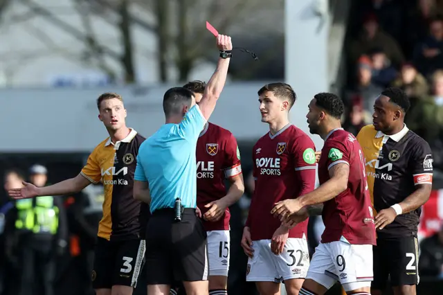 Referee Lewis Smith shows a red card to West Ham United's Potts