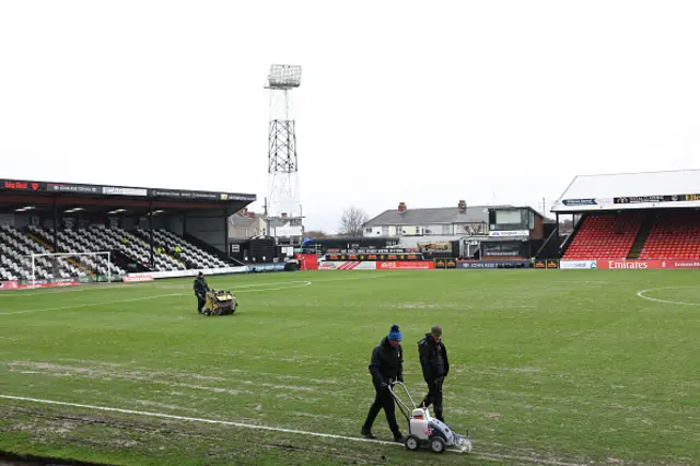 Members of the ground staff prepare the pitch