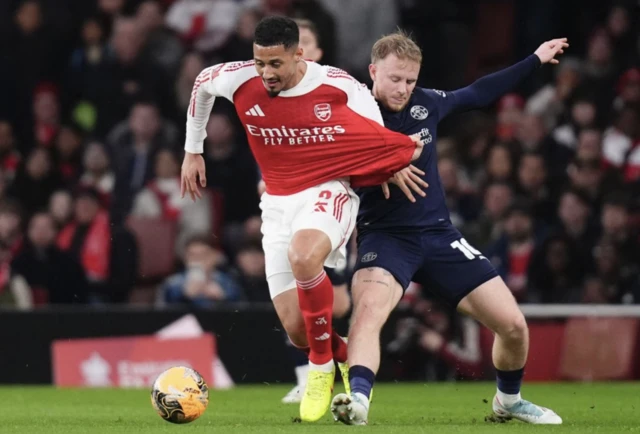 Arsenal's William Saliba and Wigan Athletic's Joe Taylor battle for the ball